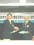 調印式で握手をする浦安市長・松崎氏(左)と明海大学長・高倉氏(右)