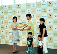 第一号の宿泊客に記念品(水野真紀さんのレシピで作られた特製チョコレートクッキー)が水野真紀さんから手渡された