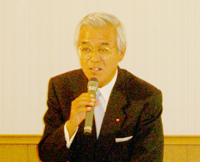 会見で挨拶する小川修武会長
