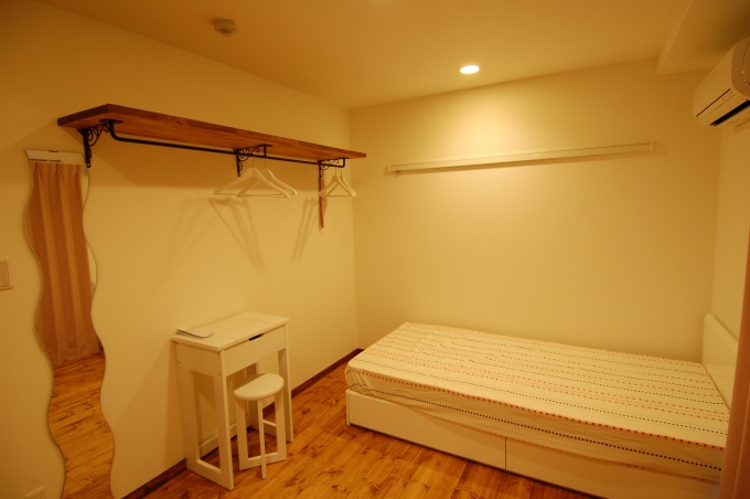 居室内部。居室はすべて6畳大。ベッドや姿見、ドレッサーを兼ねるテーブルなどの仕様も統一している