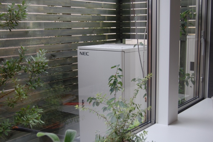 キッチン裏面に設置された蓄電池。10kwの容量を持ち、停電時も約20時間生活に必要な電力を供給できる。リチウムイオン電池はNEC製で、量販時は6kwが主力となる予定。電池の供給価格で販売価格が決まるが、概ね150万円程度となる予定