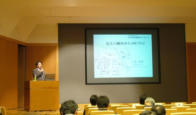 シンポジウムの様子。近江八幡市のエコ村づくりについて講演するNPO法人エコ村ネットワーキング理事長・滋賀県立大学副学長の仁連孝昭氏