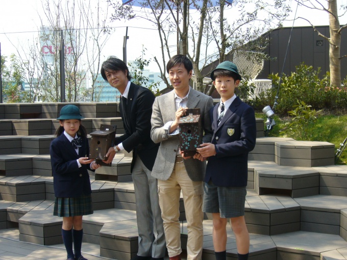 地元小学生らによる巣箱贈呈式の様子。同社の大久保次朗氏(写真中央左)とNAP建築設計事務所の中村拓志氏(写真中央右)