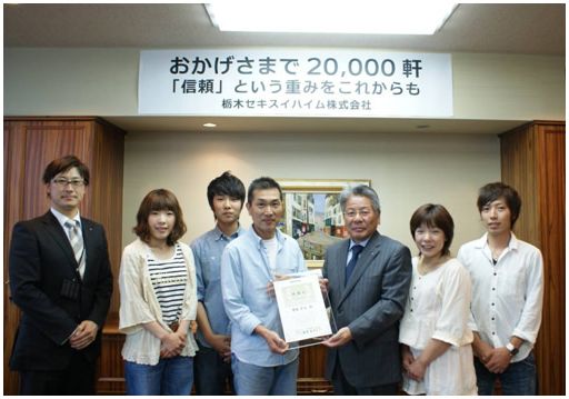 2万棟目を建設した齋藤氏一家に感謝状を贈呈する様子