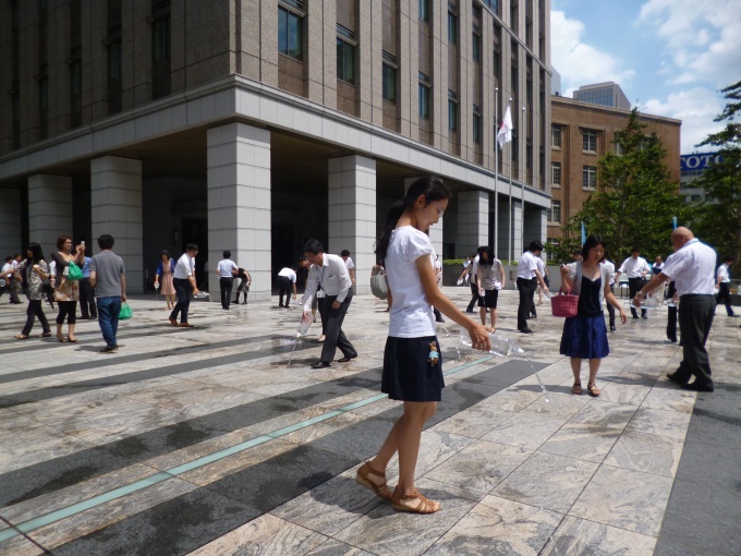 ペットボトルやひしゃくを使い、参加者全員による打ち水を行なった。実施後の気温測定で、2.3度の気温低下が確認された