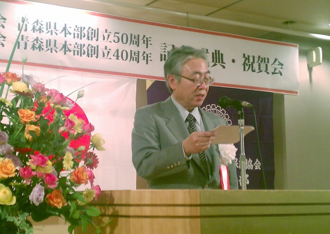記念式典で多くの来場者を前に挨拶に立つ原 勝博氏