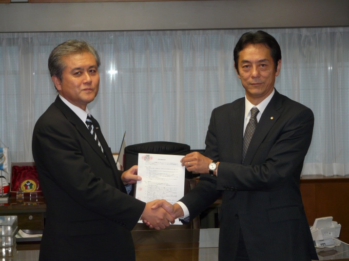 提携調印式にて。写真右はハトマーク支援機構理事長の和氣猛仁氏、左はアットホーム取締役の庄司利浩氏