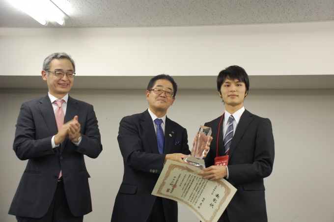 「JPM夢の賃貸住宅学生コンテスト」で最優秀賞を受賞した西尾甚一氏に賞状とトロフィーを手渡す、同協会・三好 修会長(中央)。左は、東京都支部・塩見紀昭支部長