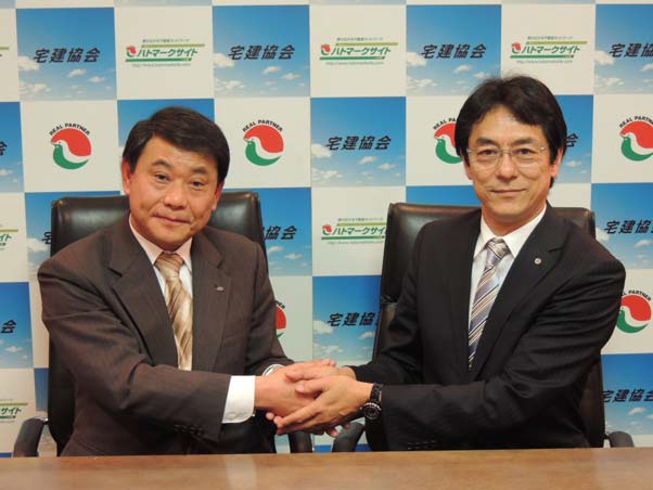 ハトマーク支援機構理事長の和氣猛仁氏(右)と、JHS代表取締役社長の斉藤武司氏(左)による調印式の模様。