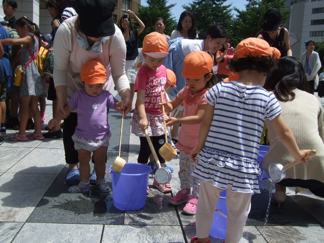 打ち水に参加する保育室の児童たち