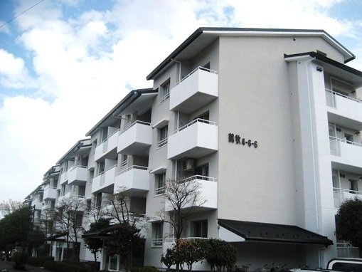 改修が終了した「エステート鶴牧4・5住宅」。外壁には外側から断熱材が貼りこまれ、白一色だった塗装は、新たにグレーのアクセント塗装を施された