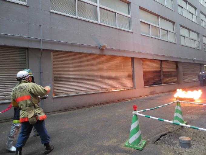 自衛団による消火活動。本来は公設消防隊が利用する屋外採水口を活用する