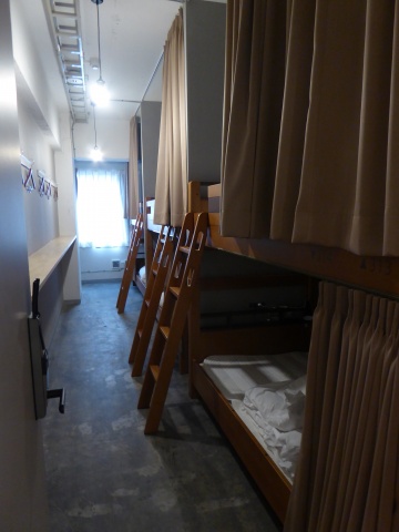 ドミトリータイプの部屋。前には荷物が置け、衣服が掛けられるスペースを確保