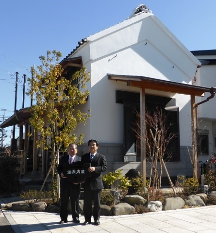 「油長内蔵」贈呈式の様子。左が高橋市長。右が中央住宅品川社長
